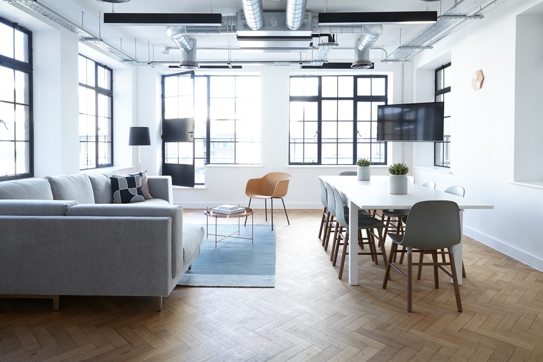 Salón luminoso con suelo de espiga y grandes ventanales