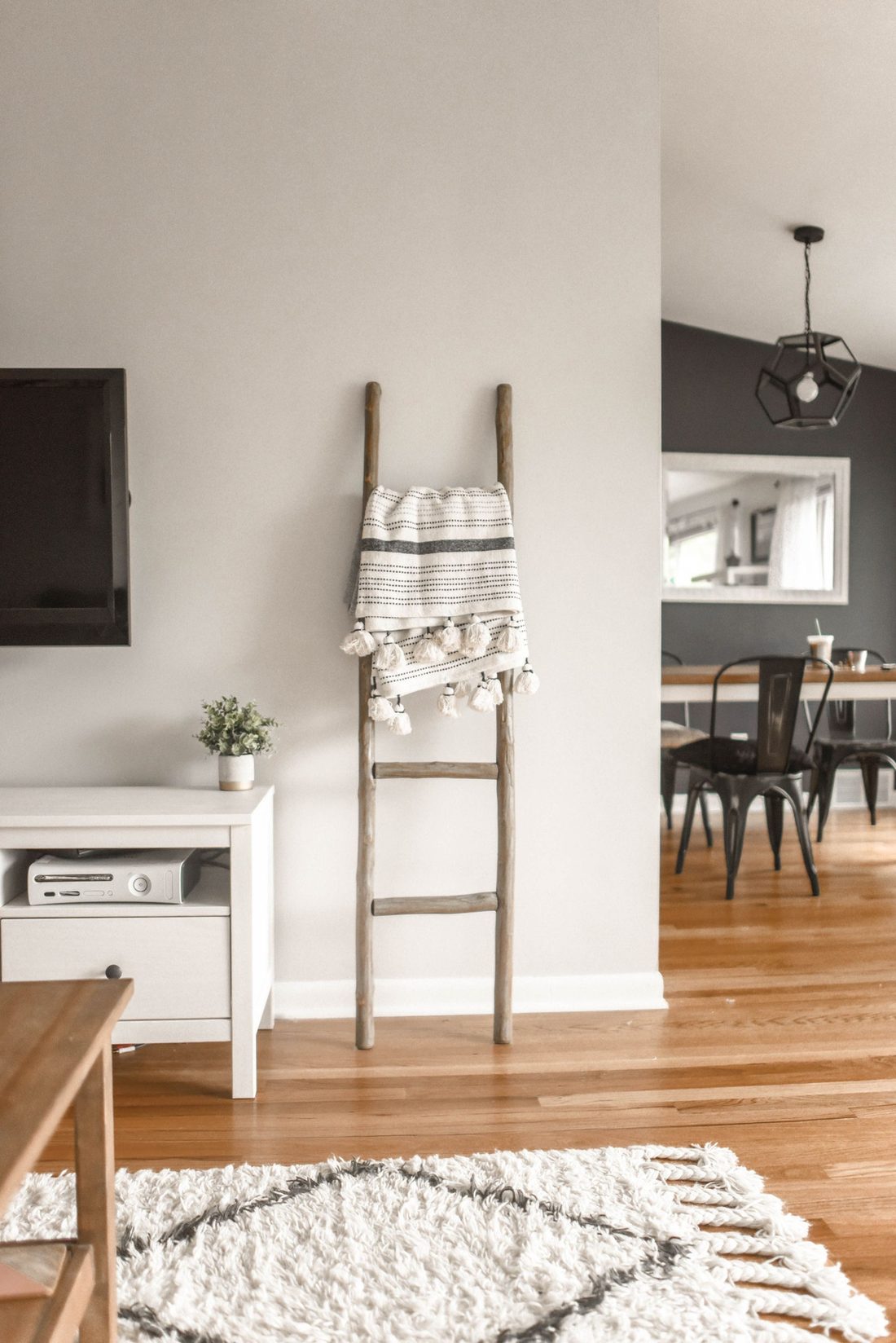 Salón en tonos neutros con escalera de madera y alfombra bereber