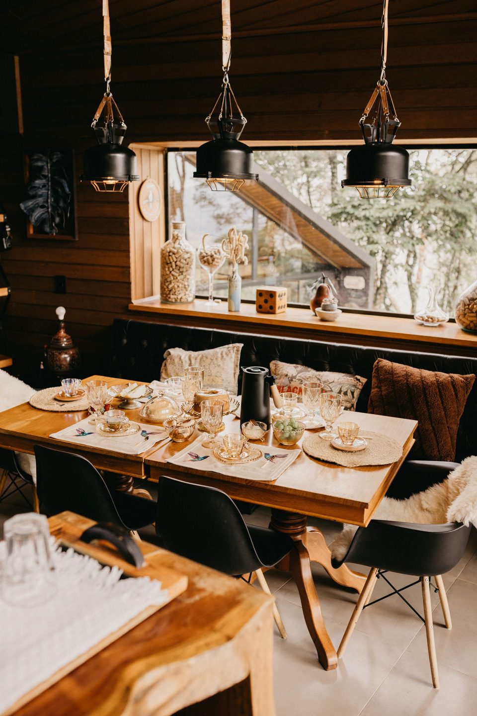Comedor de madera con lámparas colgantes y mesa vestida